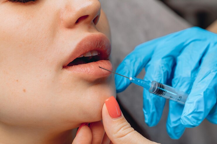 lip enlargement close up beautician s gloved hands hold syringe with filler inserts it into client s lips 161422 4988